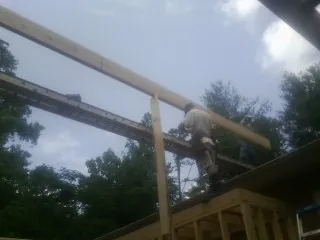 Carpenter setting a ridge beam over a new addition frame — Ice Dam Removal by Roofing Brothers in Snyder