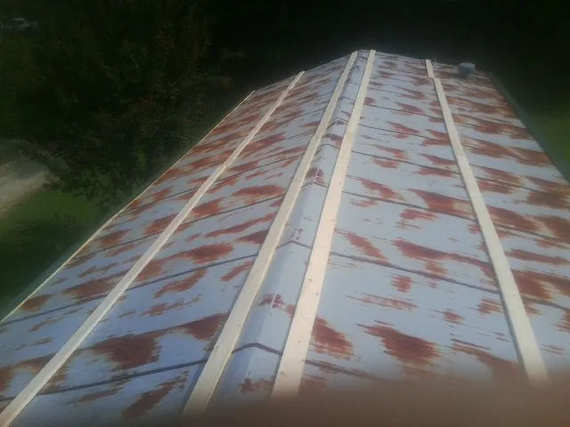 Rusted metal roof panels with new wood purlins before replacement — Storm Damage Roof Repair in Snyder by Roofing Brothers